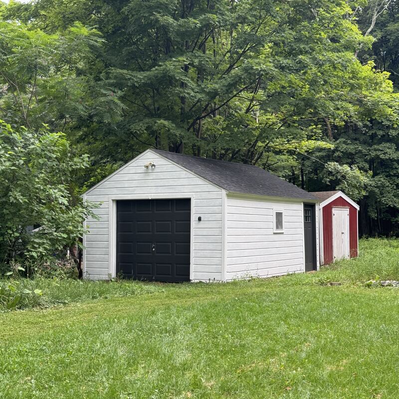 The garage and a small red shed at the edge of the yard